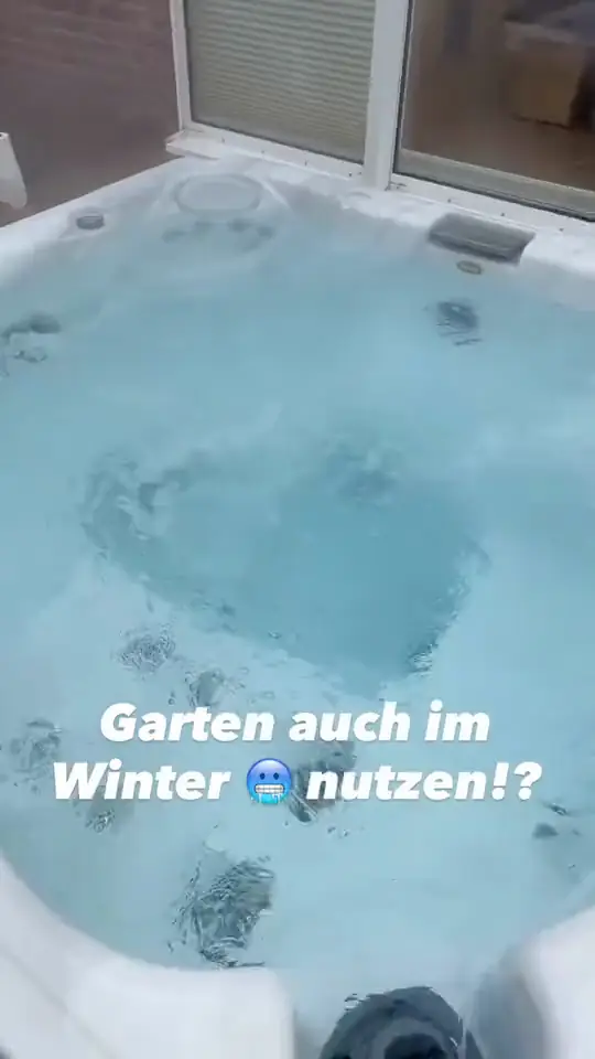 Whirlpool mit sprudelndem Wasser auf einem Holzdeck