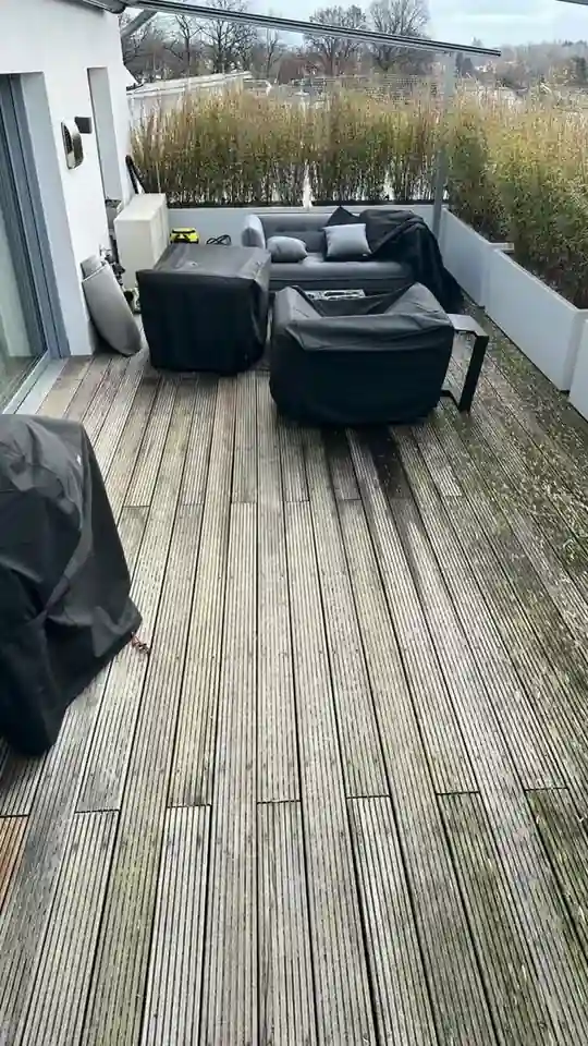 Dachterrasse mit Holzdielen, Lounge-Möbeln und Gräsern in Pflanzkästen